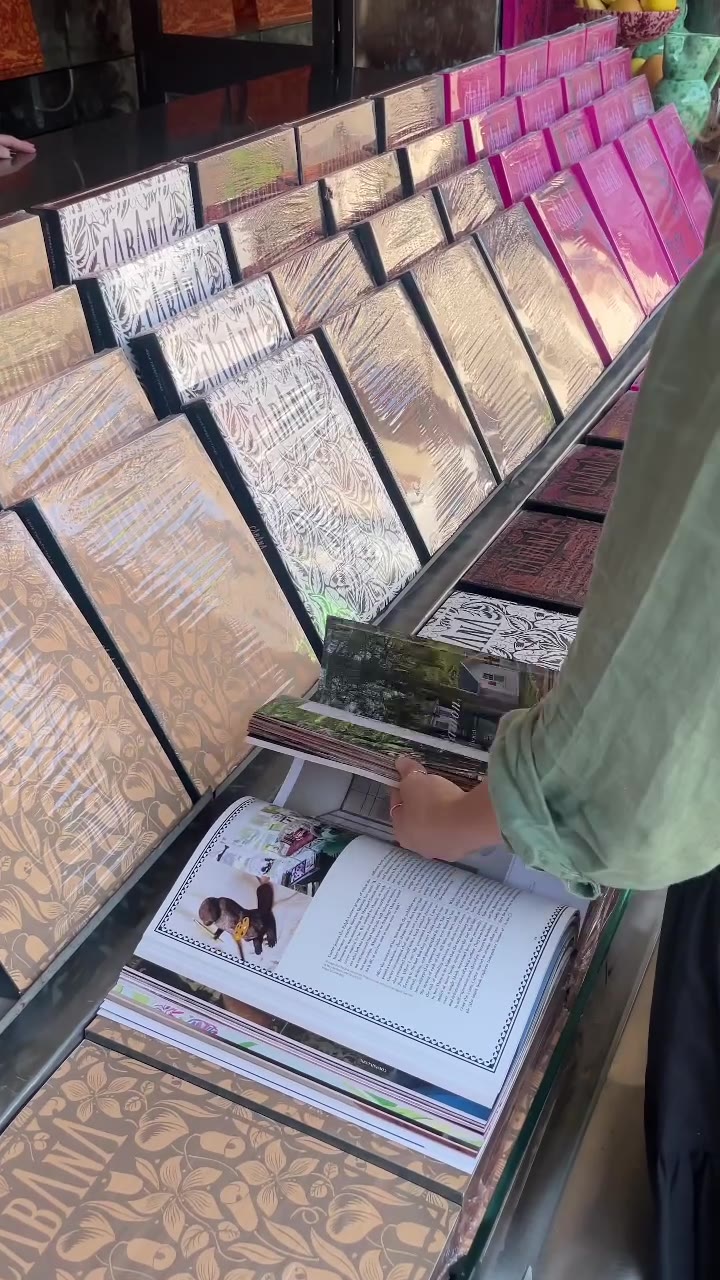 Una mano sfoglia una rivista sul bancone dell'Edicolina
